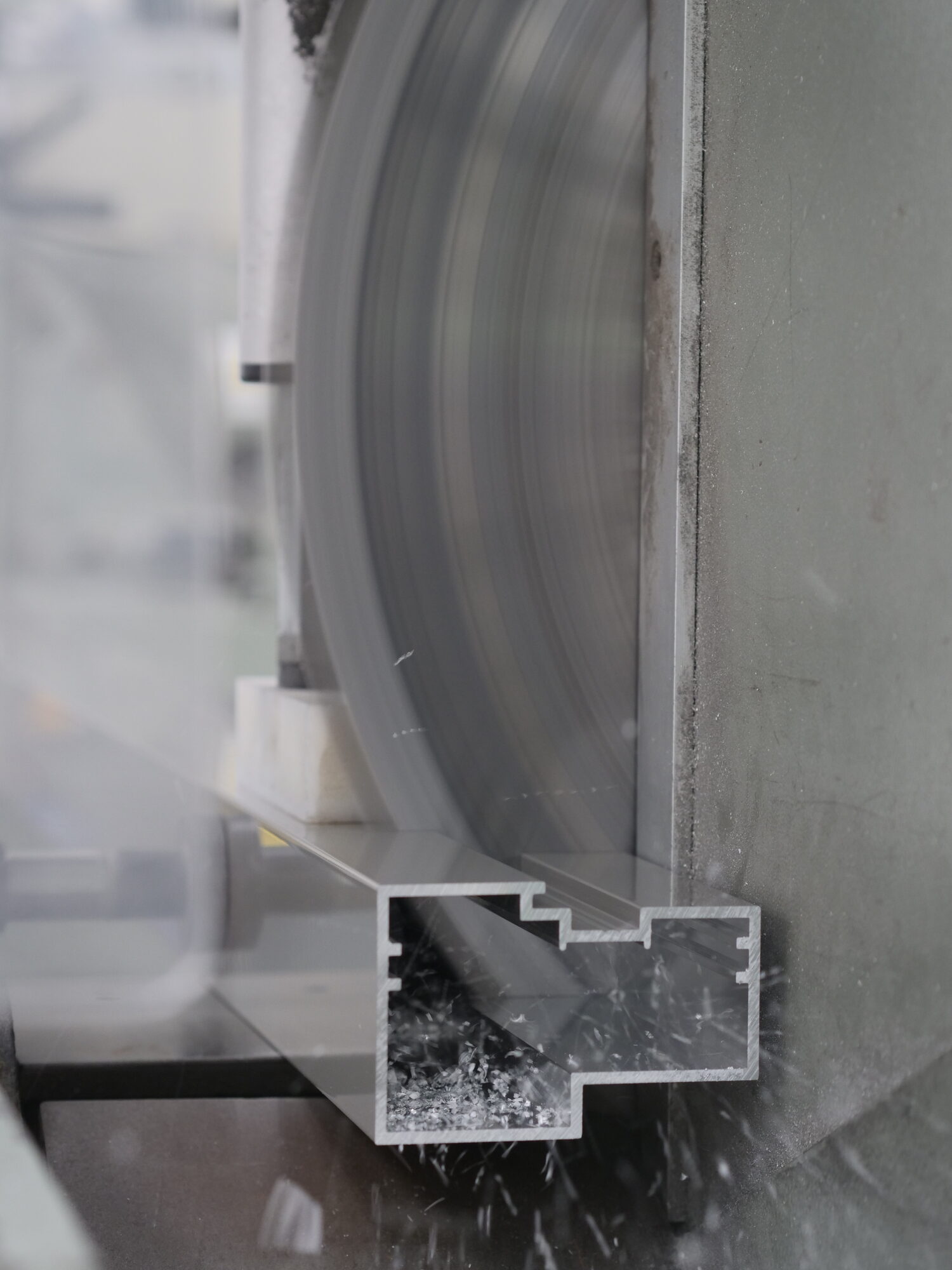 Double cross-headed saw blade cutting through aluminium profile