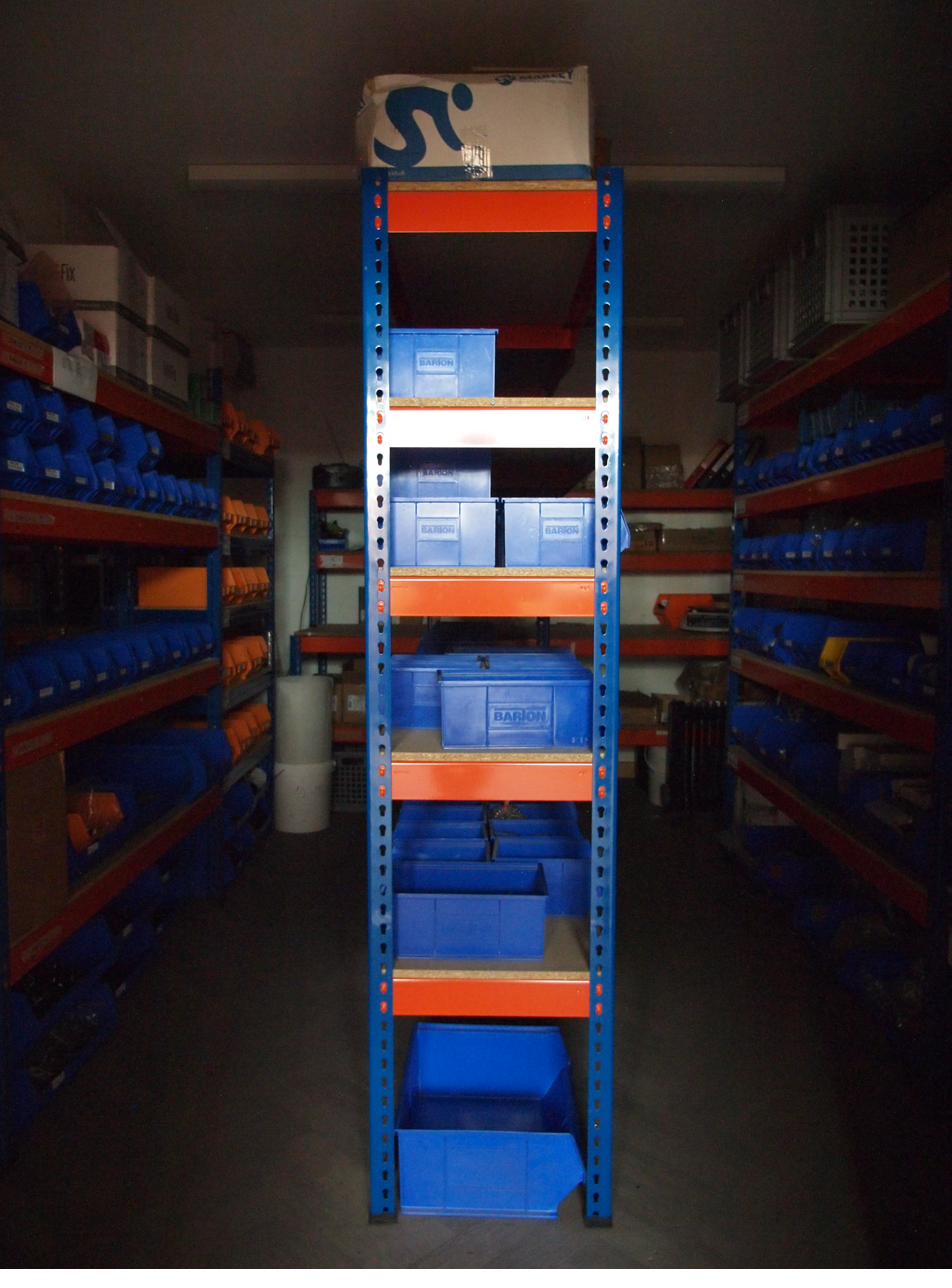 The screw room with blue and orange racking holding component bins