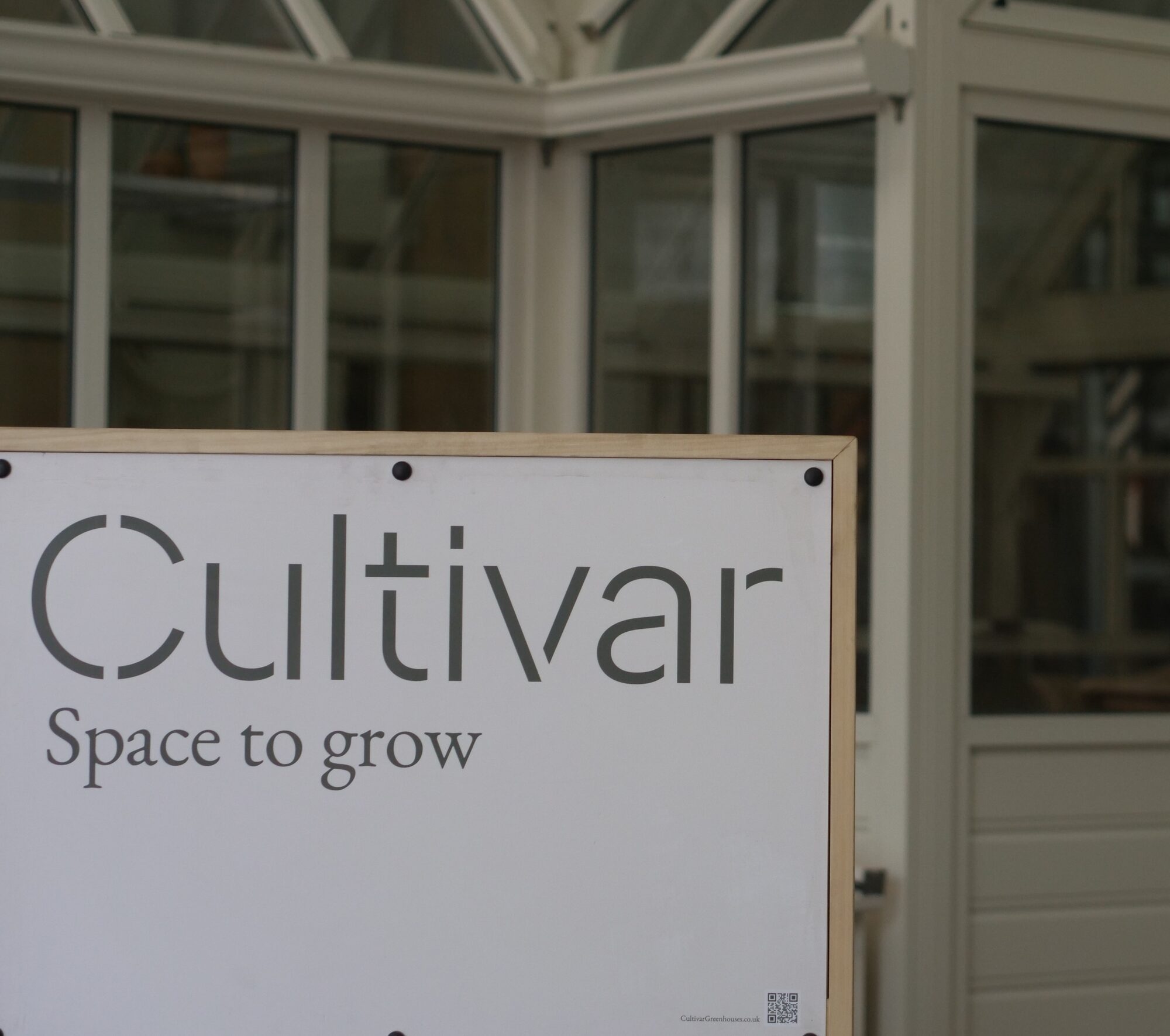Cultivar Space to Grow sign in front of a finished glasshouse