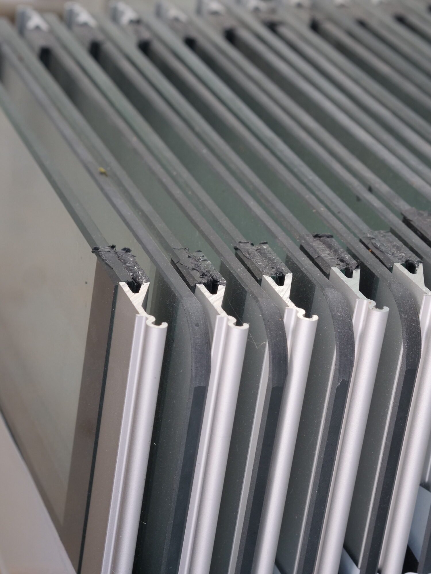 Frameless vent glass panels with metal pivot extrusions on workshop rack