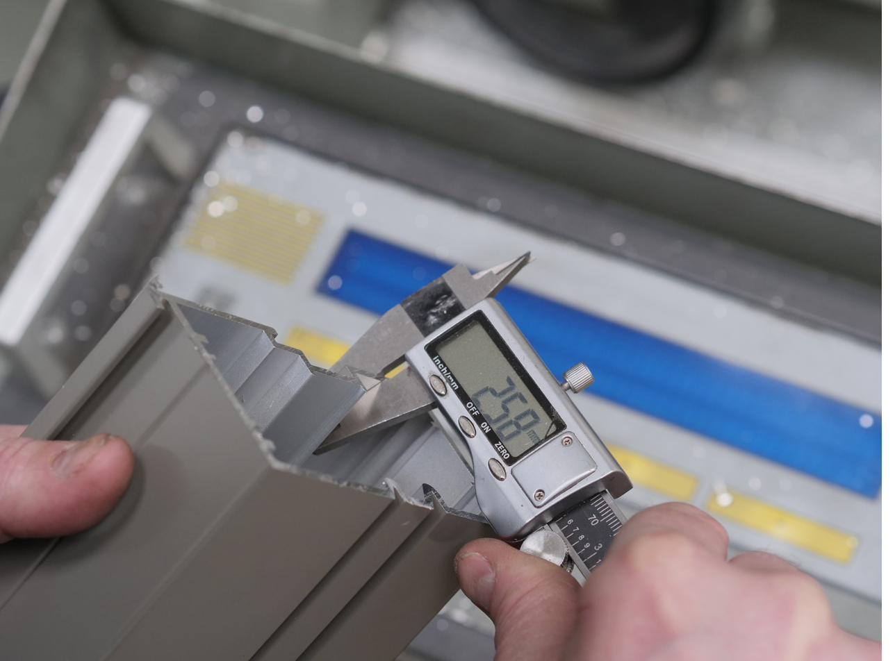 Digital vernier gauge measuring an aluminium profile in the workshop